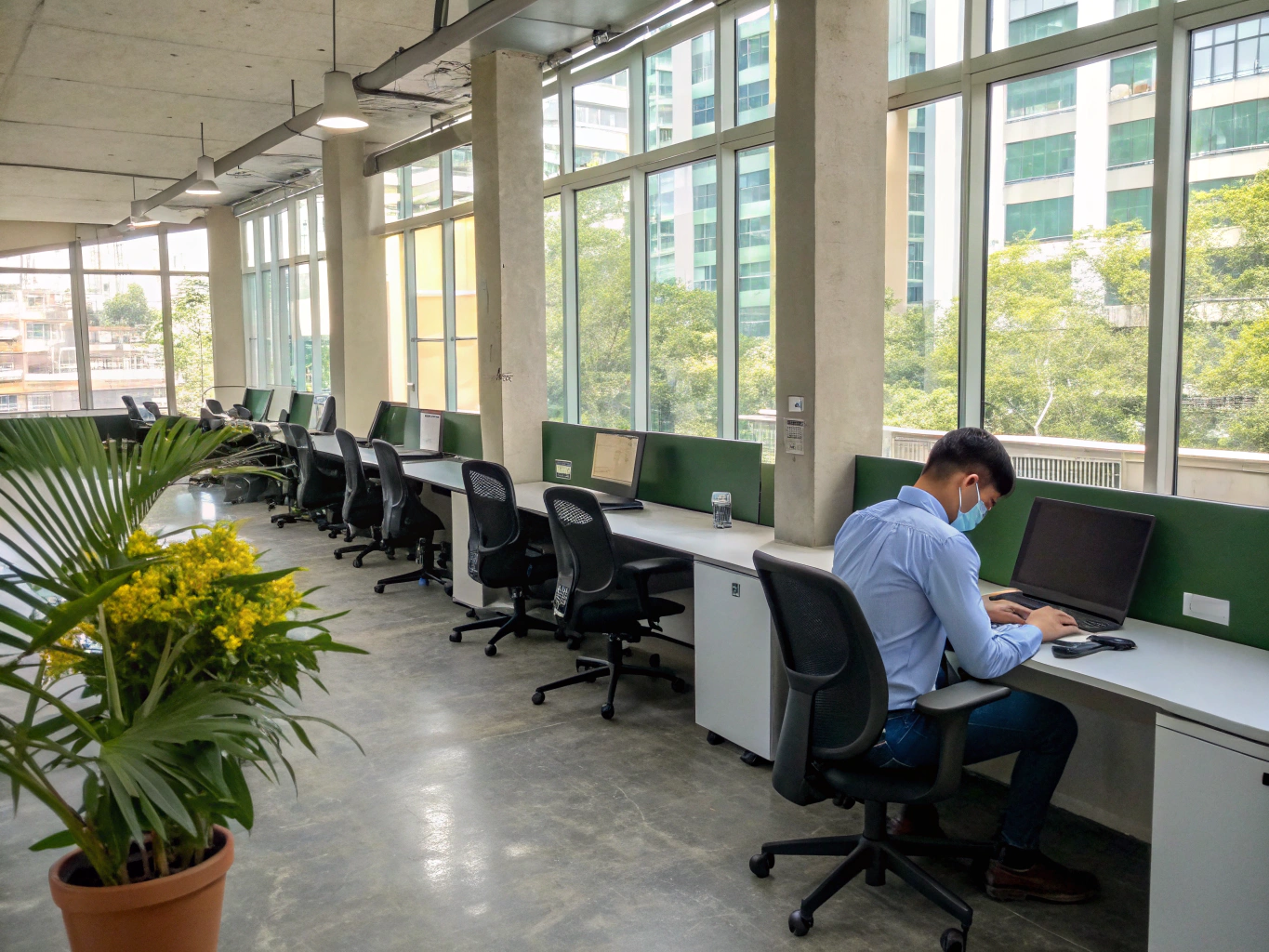 Area coworking open space con postazioni condivise e sedute ergonomiche